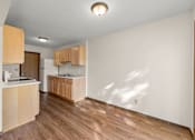 Thumbnail 4 of 14 - A kitchen with wooden floors and cabinets.