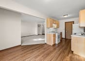 Thumbnail 3 of 14 - A kitchen with wooden floors and white appliances.