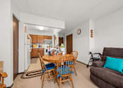 Thumbnail 4 of 11 - A dining room with a table and chairs.