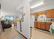 Thumbnail 1 of 11 - A kitchen with wooden cabinets and a refrigerator in the middle.