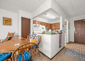 Thumbnail 2 of 11 - A kitchen with a table and chairs in the foreground.