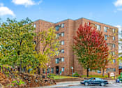 Thumbnail 11 of 11 - A brick building with trees in front of it.