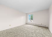 Thumbnail 10 of 23 - A room with a carpeted floor and a window showing a view of a street.