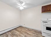 Thumbnail 7 of 23 - A kitchen with a white oven and wooden cabinets.