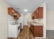 Thumbnail 6 of 23 - A kitchen with white appliances and wooden cabinets.