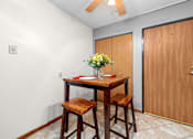 Thumbnail 9 of 16 - A dining room with a wooden table and chairs.