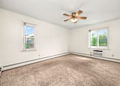 Thumbnail 9 of 18 - A room with a ceiling fan and two windows.