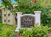 Thumbnail 11 of 18 - A sign for Dilla's Pointe Apartments stands in front of a building.