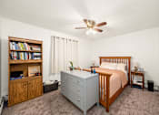 Thumbnail 8 of 15 - A bedroom with a bed, dresser, and bookshelf.