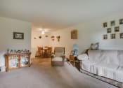 Thumbnail 6 of 14 - a living room with a couch and a chair and a dining room table