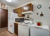 Thumbnail 4 of 14 - a kitchen with white appliances and wooden cabinets and a refrigerator