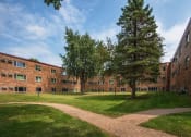 Thumbnail 2 of 14 - the exterior of a brick building with grass and trees