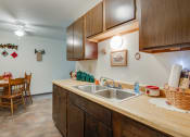 Thumbnail 5 of 14 - a kitchen with a sink and a dining room with a table