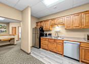 Thumbnail 16 of 23 - A kitchen with wooden cabinets and a stainless steel refrigerator.