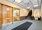 Thumbnail 3 of 23 - A hallway with a staircase leading to the second floor.