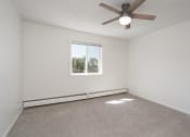 Thumbnail 24 of 27 - an empty living room with a ceiling fan and a window