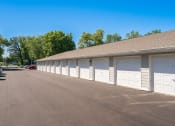 Thumbnail 4 of 27 - a row of garages with white garage doors in a parking lot