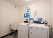 Thumbnail 23 of 27 - a laundry room with two washing machines and a sink