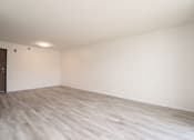 Thumbnail 11 of 27 - an empty living room with wood flooring and white walls