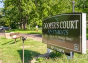 Thumbnail 1 of 27 - a sign for coopers court apartments in a park