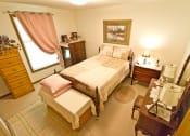 Thumbnail 12 of 14 - a bedroom with a bed and a dresser and a mirror