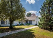 Thumbnail 8 of 14 - a white house with trees and a sidewalk