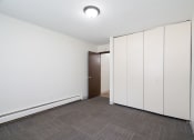 Thumbnail 16 of 22 - a bedroom with white cabinets and a door to a closet