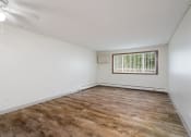 Thumbnail 13 of 22 - an empty living room with wood flooring and a window