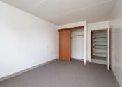 Thumbnail 13 of 21 - an empty room with white walls and a closet with a wooden door