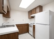 Thumbnail 18 of 21 - a kitchen with white appliances and wooden cabinets and a white refrigerator