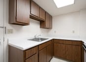 Thumbnail 15 of 21 - an empty kitchen with wooden cabinets and a sink