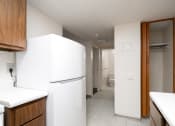 Thumbnail 10 of 21 - a kitchen with white appliances and a hallway to a bathroom