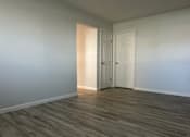 Thumbnail 3 of 10 - A room with a white door and a wooden floor.