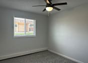 Thumbnail 5 of 10 - A room with a ceiling fan and a window with blinds.