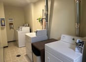 Thumbnail 10 of 10 - A white washing machine is in a room with a white dryer.