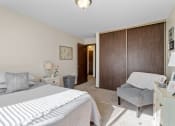 Thumbnail 17 of 23 - a bedroom with a bed and a chair and a closet