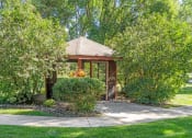 Thumbnail 5 of 23 - a gazebo in a garden with trees and a sidewalk