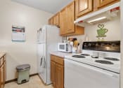 Thumbnail 9 of 23 - a kitchen with white appliances and wooden cabinets and a white refrigerator