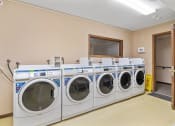 Thumbnail 22 of 23 - a washer and dryer in a laundry room with four washing machines