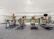 Thumbnail 17 of 30 - A gym with treadmills, elliptical machines, and other exercise equipment.