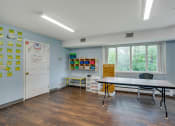 Thumbnail 14 of 18 - a classroom with a table and chairs in front of a window