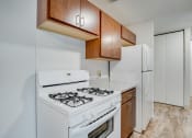 Thumbnail 6 of 18 - a kitchen with white appliances and wooden cabinets and a white refrigerator