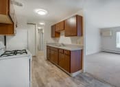 Thumbnail 7 of 18 - an empty kitchen with wooden cabinets and a stove top oven