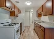 Thumbnail 5 of 18 - a kitchen with wood cabinets and white appliances and a counter top with a stove and