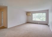 Thumbnail 8 of 18 - the living room of an apartment with carpet and a large window