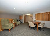 Thumbnail 5 of 7 - A room with a table and chairs in the middle of the room.
