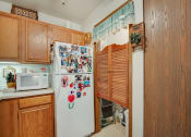 Thumbnail 12 of 19 - a kitchen with a white refrigerator and wooden cabinets