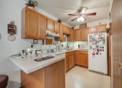 Thumbnail 11 of 19 - a kitchen with white appliances and wooden cabinets