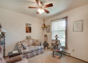 Thumbnail 16 of 19 - a living room with a couch and a ceiling fan