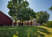 Thumbnail 7 of 19 - a large lawn in front of a red house with a tree